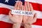 Hands of a man hold the inscription I have a dream, against the background of the American flag.