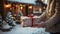 The Hands of a Man Holding a Wrapped Christmas Gift Walking Toward a House on a Snowy Winter Evening