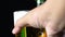 Hands of man picking a glass of beer against dark background