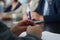 Hands of a man in a suit holding a fountain pen during a business meeting. An official, deputy, lawyer or businessman. Reportage.