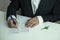 hands of a man in a suit signing a mortgage loant