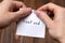 Hands of a man tearing a piece of paper with inscription front end