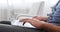 Hands of man typing on laptop sitting on sofa