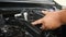 Hands of man using blue micro fiber fabric to clean the car engine