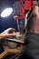 Hands of a man who drills a metal part on a machine tool