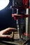 Hands of a man who drills a metal part on a machine tool