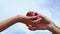 Hands of a man and a woman close-up, passing an apple to each other.