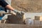 Hands of man working in construction site nailing in the wood with a hammer