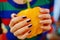 Hands with manicure of young girl wear in colored sweater, holing red sweet pepper