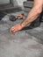 Hands of a manual worker laying concrete paving blocks