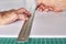 Hands marking a white board, ruller and pencil on a green mat