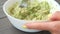 Hands mashing avocado in bowl with a fork. Table top view footage. Healthy food cooking.