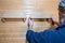 hands of a master carpenter attach a wooden shelf to the wall. Production of handmade furniture to order