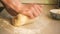 hands of the master knead the dough close-up. Baking from wheat flour. Cooking food at home