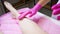 The hands of the master of sugar hair removal, who applies the cream to the leg after removing unwanted hairs