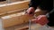 Hands of master twist washer with nut onto a threaded steel stud into concrete floor of rough floor for installation of wooden