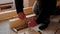 Hands of master twist washer with nut onto a threaded steel stud into concrete floor of rough floor for installation of wooden