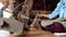 Hands of mature Asian woman spinning cotton with old traditional wheels machine in Thailand