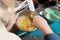 Hands of mature female mixing ingredients with whisker in metallic bowl by table