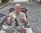 Hands of mature glassblower holding glass rod over burner flame. Process of artistic glass processing, flamework.