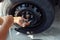 Hands of mechanic pick up the nut of car wheel.Change a flat car tire at car park with Tire maintenance, damaged car tyre