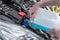 Hands of mechanic pouring washer in a car