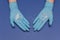 Hands in medical gloves on blue background. Glitter little stars in hands. Christmas and New Year card concept. Top view photo,