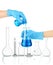 Hands in medical gloves and flasks with reagents