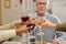 Hands of members of intercultural family clinking with glasses of wine