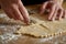 hands meticulously decorating pastry dough with a small knife