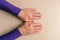 Hands of middle aged woman with palms down. Mockup on desk background. Template closeup with copy space. Top view. Slightly loose