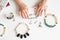 Hands of middle-aged woman touching various jewels top view