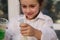 Hands of a mischievous little girl holding a laboratory test tube and flask, watching the taking place chemical reaction