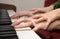 Hands of mother and child by piano plaing