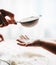 Hands of mother and child sieving flour