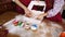 Hands of mother and her daughter put amazing Christmas cupcakes into the box.