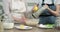 Hands of mothers and daughters prepare muffins, knead the dough with tart lemon zest, close up