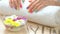 Hands with multicolored manicure on white towel.