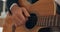Hands, musician and playing acoustic guitar strumming strings in the studio at home. Hands of talented artist or
