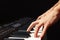 Hands of musician playing the electronic synth on black background