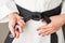 Hands with nail polish of a girl with a black belt in martial arts,