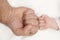 hands of a newborn and an adult parent clenched into a fist, high quality photo