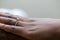 Hands of an nigerian couple. She is wearing an engagement ring