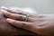 Hands of an nigerian couple. She is wearing an engagement ring