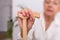 Hands of an old woman with a cane, Elder lady sitting on the couch with wooden walking stick. Cropped shot of a senior woman