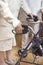 Hands of an old woman on the handles of a walker with brakes. The nurse helps the old woman.