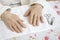 Hands of an old woman prepared for a cosmetic treatment.