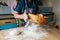 Hands of old woman sifting flour through a sieve onto dough