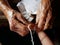 Hands of old woman tying a white string  Sai Sin  around her granddaughter hands - Thai traditional blessing from an elder one