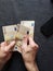 hands of an older man counting european banknotes